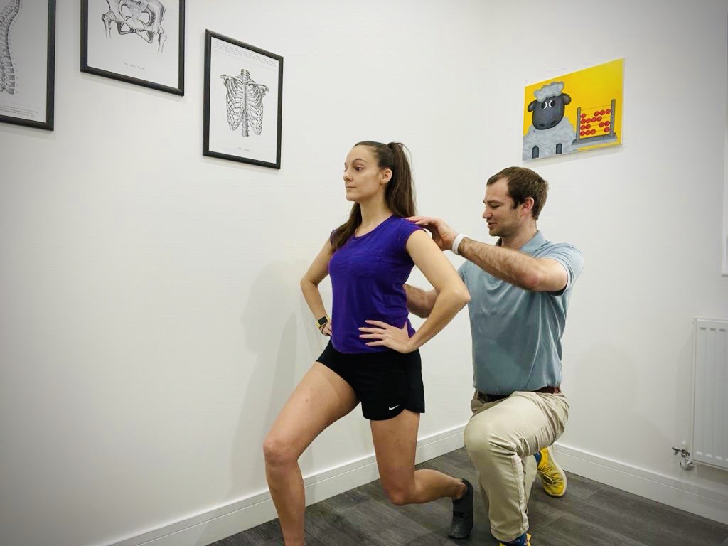Physio assessing movement and exercise correction of a patient