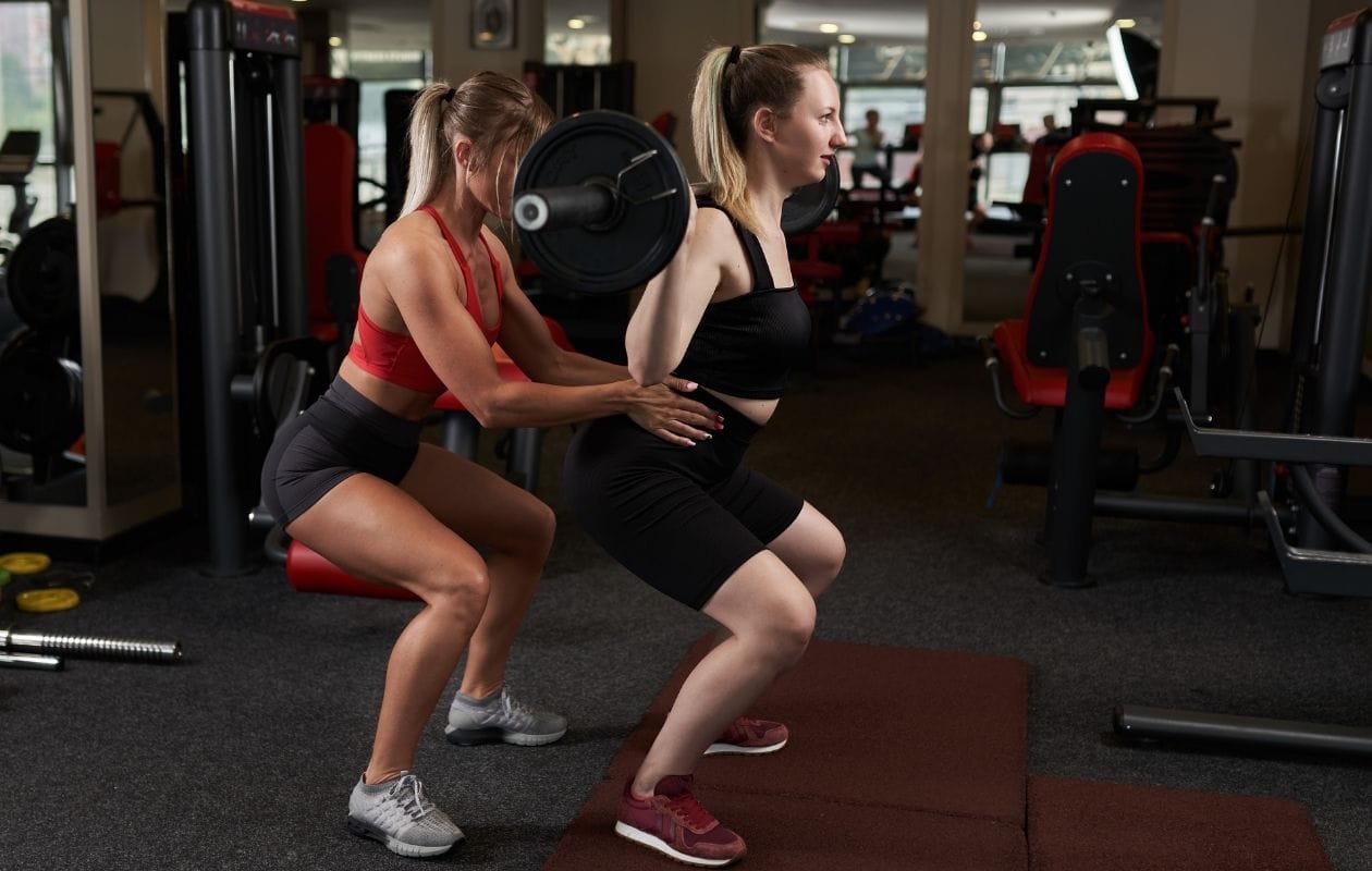 A trainer helping a client in the gym