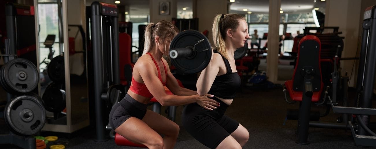 A trainer helping a client in the gym