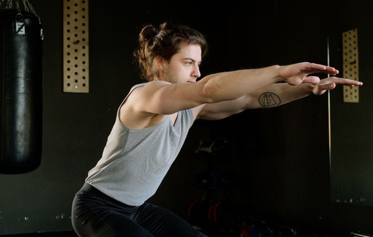 A person squatting in the gym