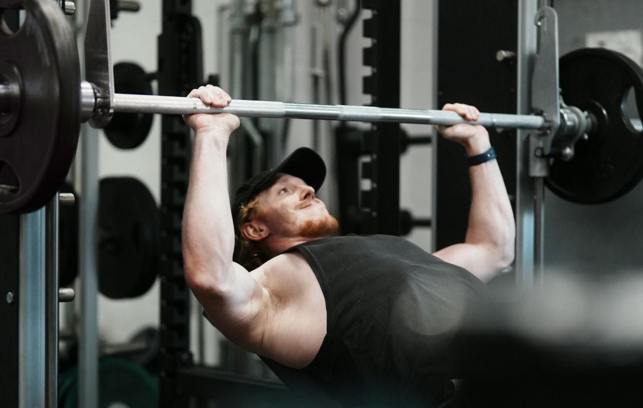 Man lifting a smith machine bar in a gym