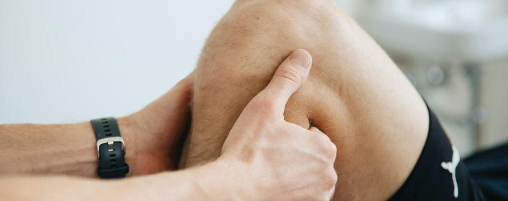 Physiotherapist examining a patient’s knee during a sports injury physiotherapy session