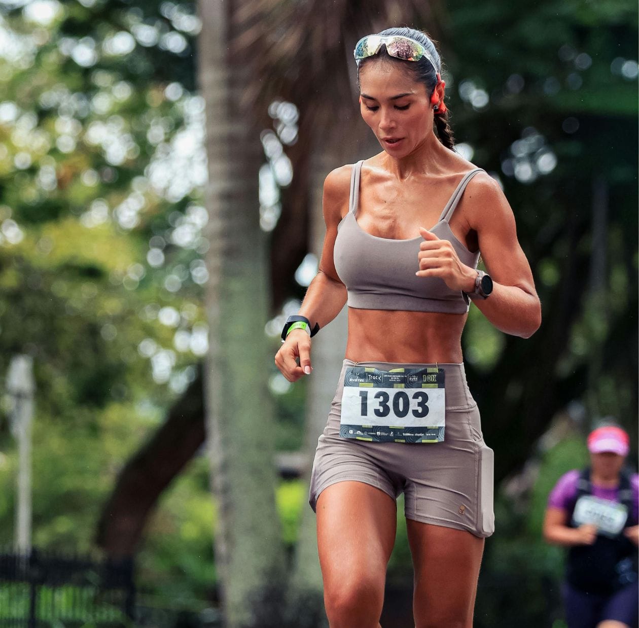 Female distance runner during a 10K road race, supported by running injury rehabilitation in Manchester