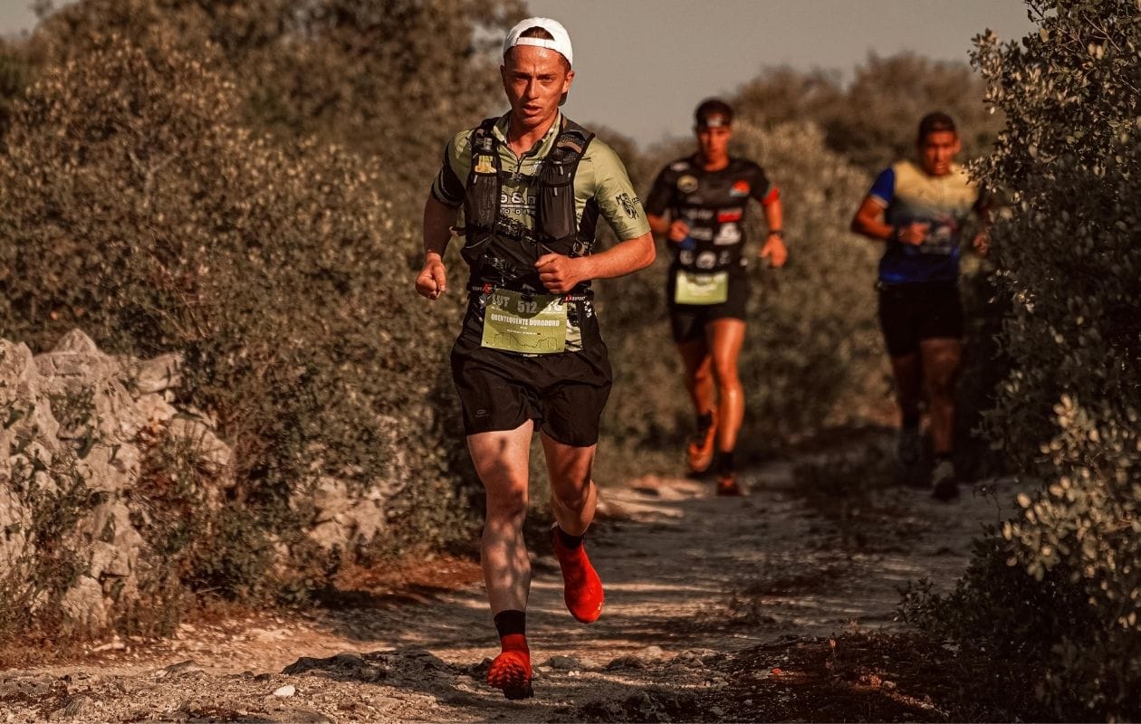 Group of trail runners racing along a rugged off-road path, representing the foot and ankle loading demands of trail and endurance running