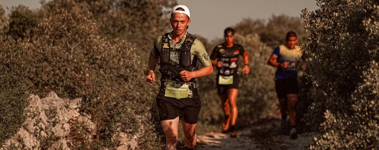 Group of trail runners racing along a rugged off-road path, representing the foot and ankle loading demands of trail and endurance running