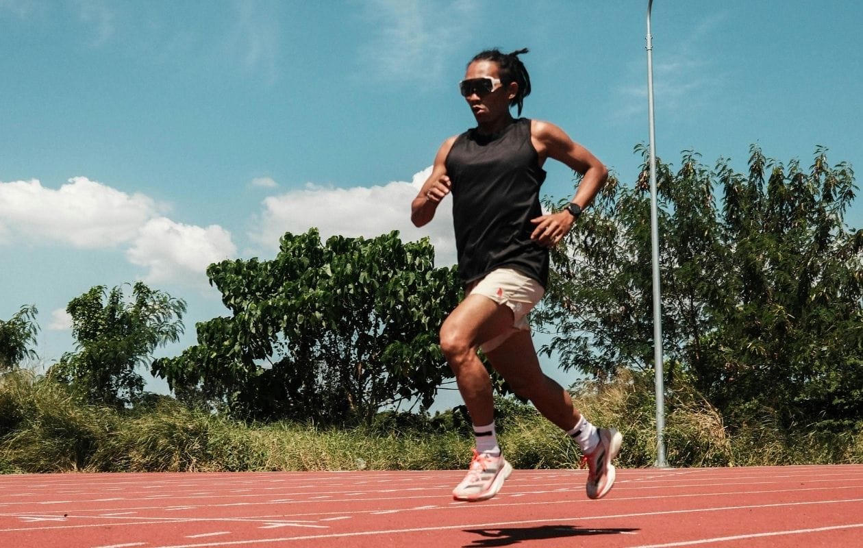 Female runner sprinting on an athletics track, demonstrating a confident return to running after hip injury rehabilitation