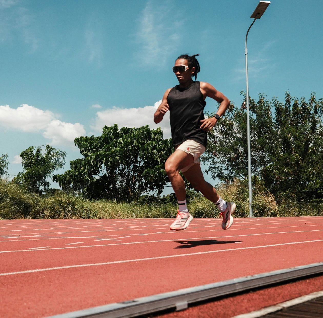 Female runner sprinting on an athletics track, demonstrating a confident return to running after hip injury rehabilitation